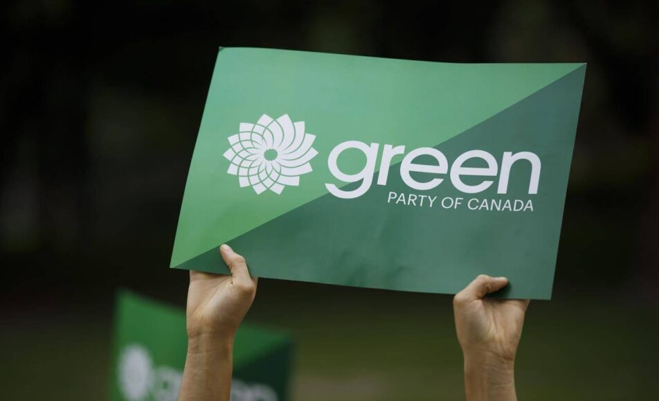 Two hands holding up a Green Party of Canada sign